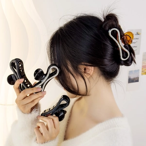 Detail showing amber and black 8-shaped hair claws with rhinestone embellishments