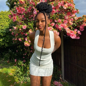 Mini vestido blanco sin mangas de punto acanalado con cuello cuadrado en un jardín