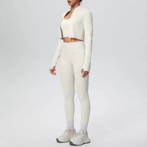 Vista laterale del set da yoga 3 pezzi bianco crema con pantaloni a vita alta e giacca zip
