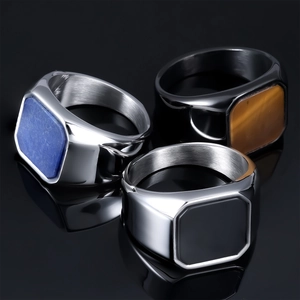 Macro shot of men's stainless steel square rings with lapis, tiger eye and black enamel
