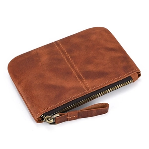 Detailed close-up of retro brown crazy horse leather texture and hand-stitched zipper pouch