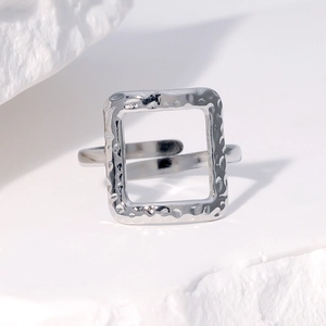 Minimalist square hammered silver open ring made of stainless steel on white rock