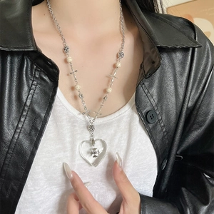 Close-up of gothic beaded necklace featuring a transparent heart and cross pendant
