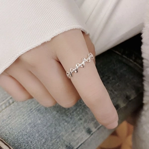 Detailed view of an S925 sterling silver irregular wavy intertwined ring worn on a finger