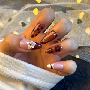 Detailed view of almond shaped press-on nails with 3D floral accents and leopard prints