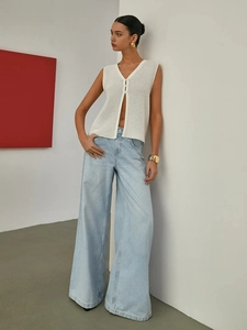French hollow knit vest in white paired with light blue wide-leg jeans for a chic modern look
