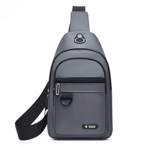 Detailed view of gray oxford fabric crossbody bag with multiple zipper pockets and D-ring