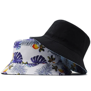 Set of two reversible bucket hats with plain black and tropical leaf patterns for sun protection