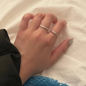 Macro view of minimalist 925 sterling silver twisted rope knot rings on finger