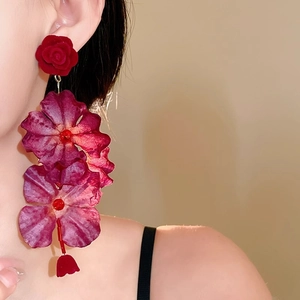 Orecchini vintage con nappe lunghe e rose in tessuto rosso scuro su modella