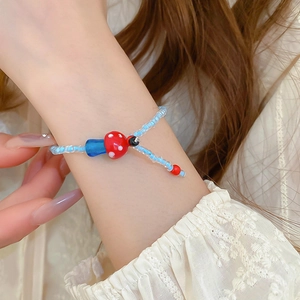 Handmade light blue glass beaded bracelet with a cute red mushroom charm for women