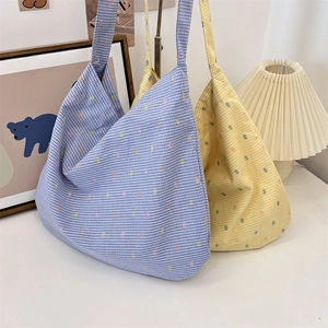 Detailed close-up of blue and yellow plaid canvas tote bags with colorful polka dots