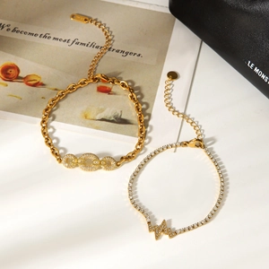 Detail shot of two gold-plated stainless steel zircon bracelets with wave and link design