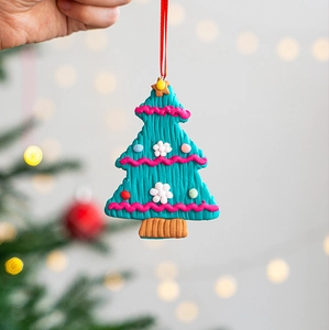 Detail of handmade green Christmas tree hanging ornament with pink wave texture