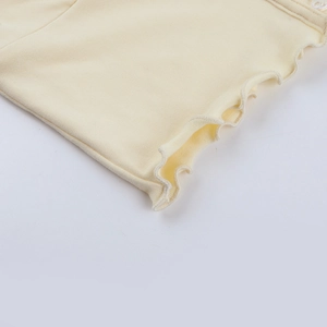 Detailed close-up of light yellow ribbed knit fabric featuring a delicate lettuce edge hem