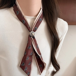 Ethnic paisley silk scarf necklace with silver heart buckle on a dark brown fabric