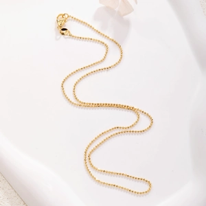 Detailed macro view of 45cm gold plated ball chain necklace with lobster clasp closure