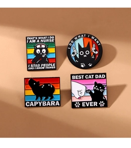 Detailed view of four black enamel animal pins featuring cats and a capybara design