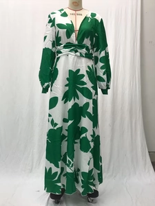 Detail of V-neckline and green floral abstract print on a loose maxi dress