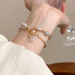 Dettaglio di un bracciale a doppio strato con cristallo ambra e perle naturali al polso
