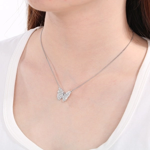 Close-up of a silver butterfly pendant necklace with sparkling inlaid stones on a model