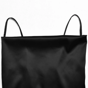 Detailed macro view of the sleek black satin neckline and delicate shoulder straps
