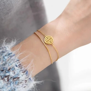 Double-layered gold titanium steel bracelet featuring a traditional Chinese coin charm