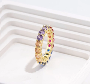 Detailed side view of golden ring set with multi-color rainbow round cubic zirconia gems
