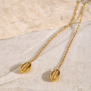 Detailed macro shot of 18k gold-plated shell pendants on a refined link chain