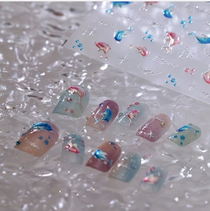 Macro shot of 3D embossed dolphin nail decals with holographic ocean theme effects