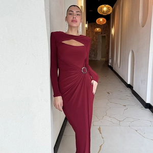 Detalle de vestido rojo vino con abertura frontal y anillo metálico en cintura