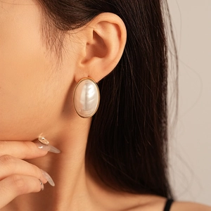 Vintage oval pearl stud earrings with gold plating on model for an elegant French style