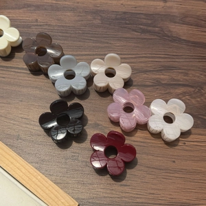 Détail macro de pinces à cheveux fleur en acrylique sur fond en bois de couleur sombre