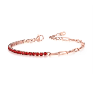 Detail of rose gold paperclip chain bracelet with round red zircon stones and lobster clasp
