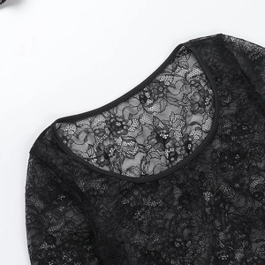 Détail de l'encolure ronde et de la dentelle florale sur le haut noir transparent