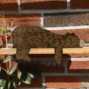 Detailed side view of a hand-carved wooden brown bear doorstop decoration