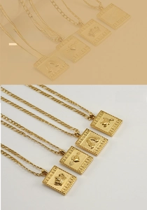 Dettaglio di catene Figaro placcate oro 18K con ciondoli quadrati a corona e cuore