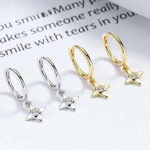 Detailed view of 925 silver and gold four-pointed star hoop earrings with sparkling zircon