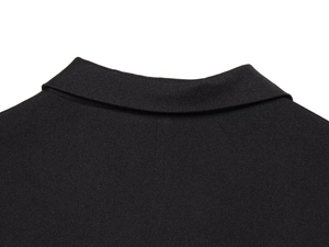 Detailed close-up of the neckline and fine stitching on the black sleeveless vest