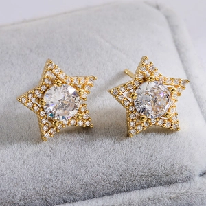 Elegant gold plated star stud earrings with sparkling cubic zirconia on grey velvet