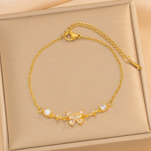 Elegant gold butterfly bracelet with clear zircons displayed in a champagne jewelry box