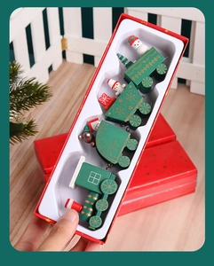 Detailed view of a four-section wooden Christmas train set in a red festive gift box