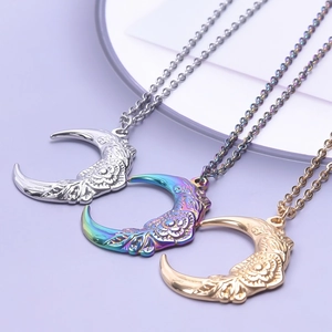 Three crescent moon necklaces with flower patterns in silver, rainbow, and gold finishes