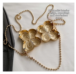 Macro view of gold butterfly shaped metal box bag with intricate wing textures