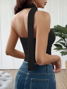 Detail view of black halter neck crop top with long streamers and backless design
