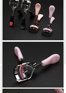 Close-up of pink eyelash curler with built-in comb and heart-shaped handle detail