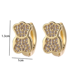 Detail of bear-shaped gold earrings with zircons and 1.3cm by 1cm size markers
