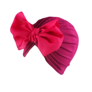 Detail view of pink baby turban hat with oversized bow made from ribbed knit fabric
