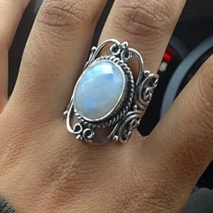Dettaglio dell'anello vintage in argento con pietra di luna ovale e traforo al dito