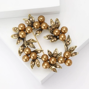 Macro detail of vintage bronze floral brooch with gold pearls and sparkling crystals